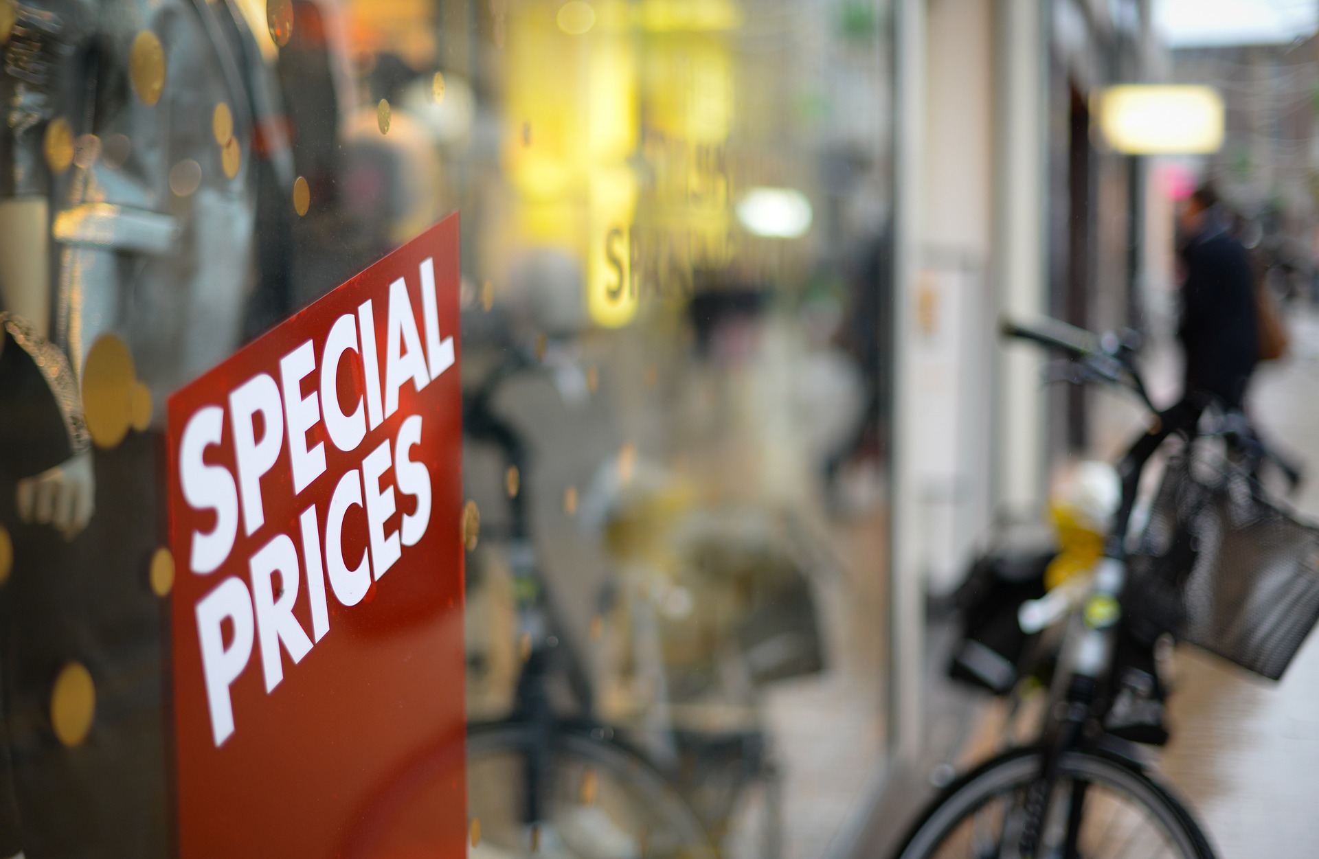 A read sign in front of a window that read Special Prices, a blurred bike in the background